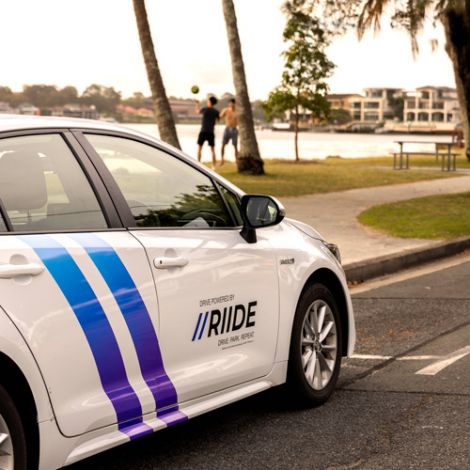 RiiDE rideshare vehicle parked by a river