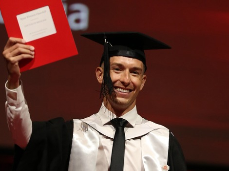 Graduate with arm up in celebration