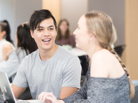Students talking while using laptop