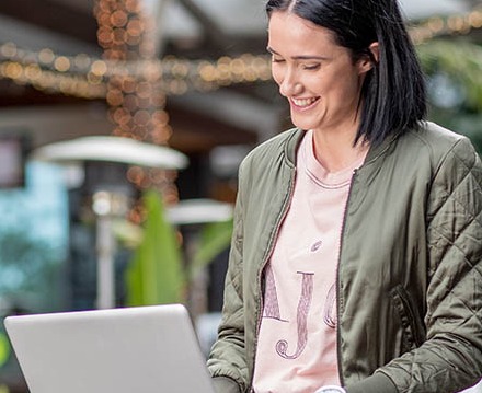 Image of a person seated with a laptop on their lap