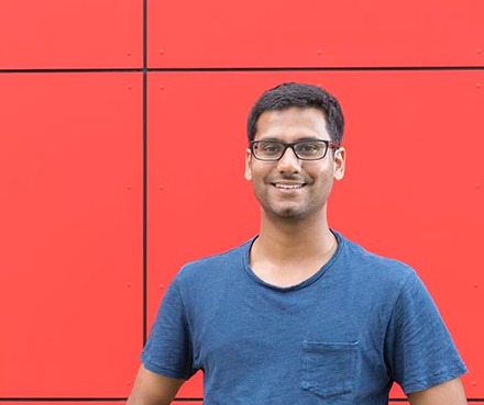Image of a person standing in front of a red wall